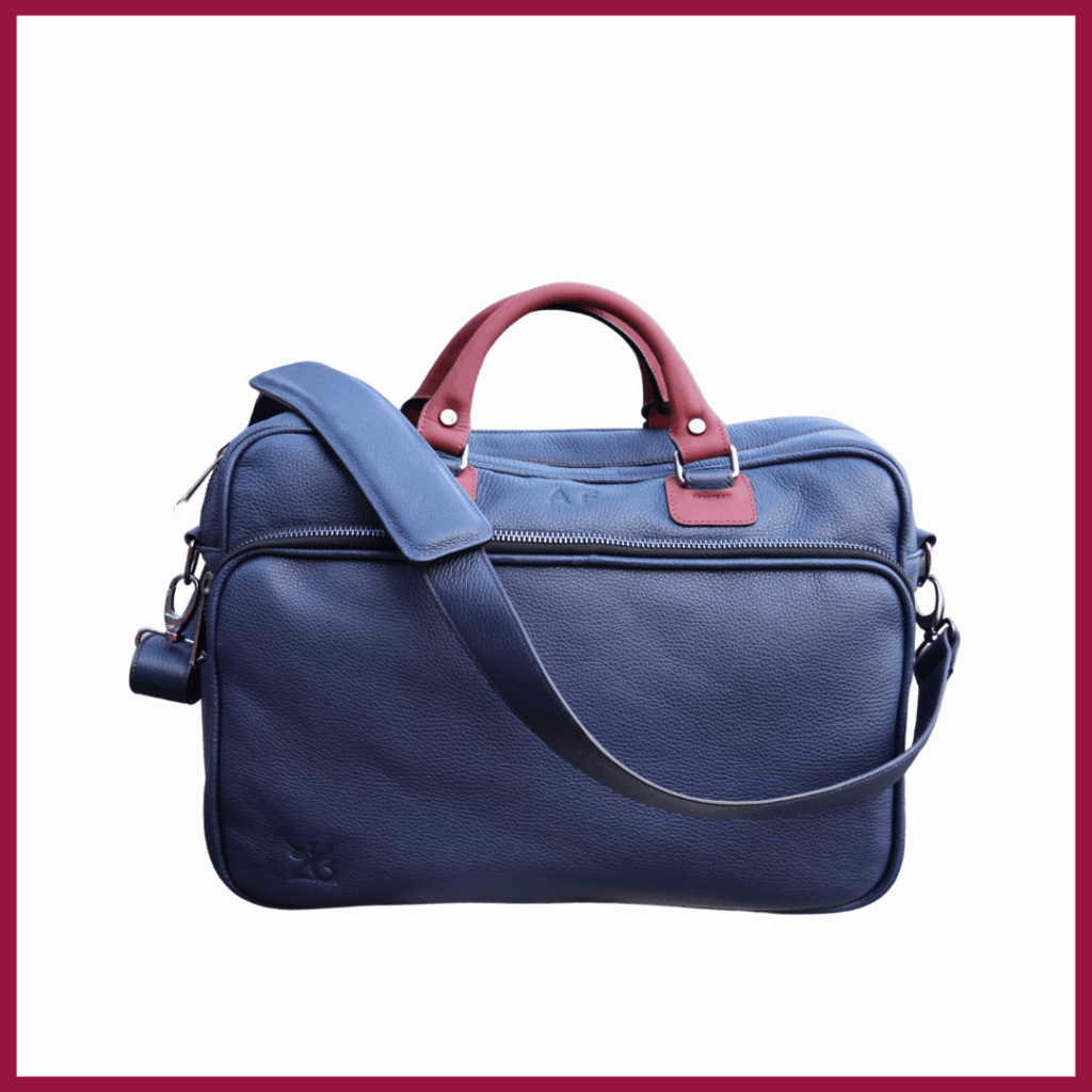 ELEGANCE business duffle bag in blue leather with burgundy handles and shoulder strap on white background